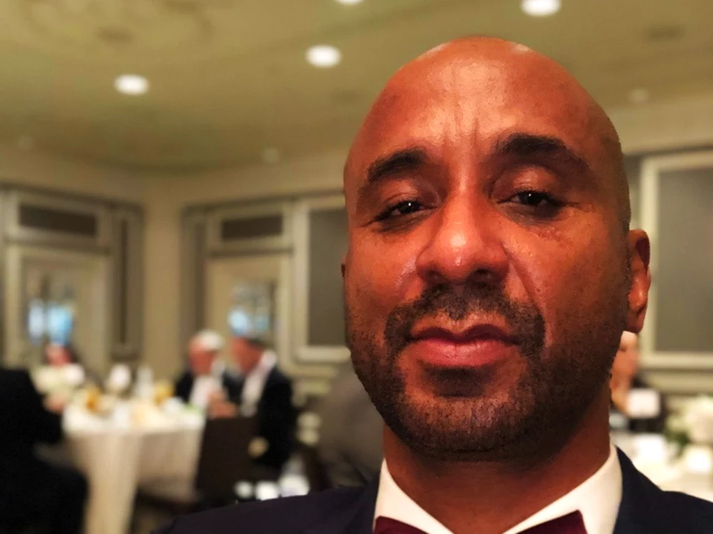 Peter C. Bennett in a dinner jacket and burgundy bow tie in a restaurant